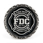 A black coin featuring Fire Department Coffee’s maltese cross logo.