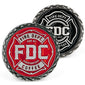 2 coins with Fire Department Coffee’s maltese cross logo, one in red and the other in black.