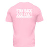 Back side of light pink t shirt with large white lettering that reads "Stay back 500 feet until I've had my coffee" across the top