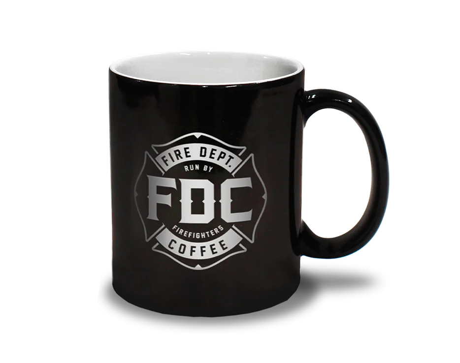 Two mugs: one showing the black mug with the FDC maltese cross logo on it when cold on the left, and the flames that appear on the mug when hot on the right.