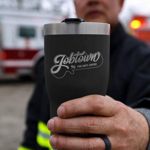 Image of firefighter holding Jobtown 20oz tumbler