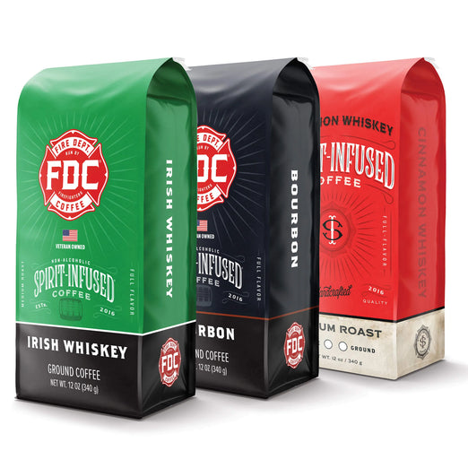 Three bags of Fire Department Coffee’s Spirit Infused Coffee. From front to back: Irish Whiskey Infused Coffee bag, Bourbon Infused Coffee bag, and Cinnamon Whiskey Infused Coffee bag.