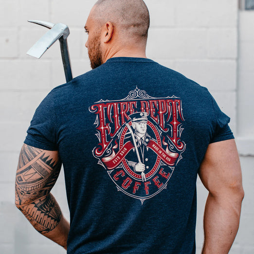 The back view of a man wearing Fire Department Coffee’s vintage fire fighter shirt